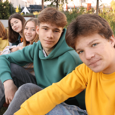 Discover how teens can maintain oral hygiene daily 2 Group of teens sitting outdoors together, representing how teens can maintain oral hygiene daily